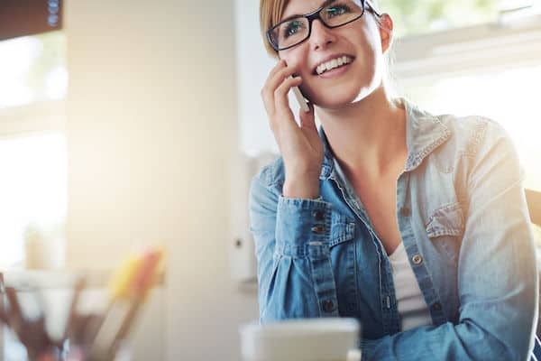 bride on cell phone - bride talking to wedding planner on cell phone - updating clients regarding postponing wedding- working from home during COVID 19 - postponing your wedding during COVID 19