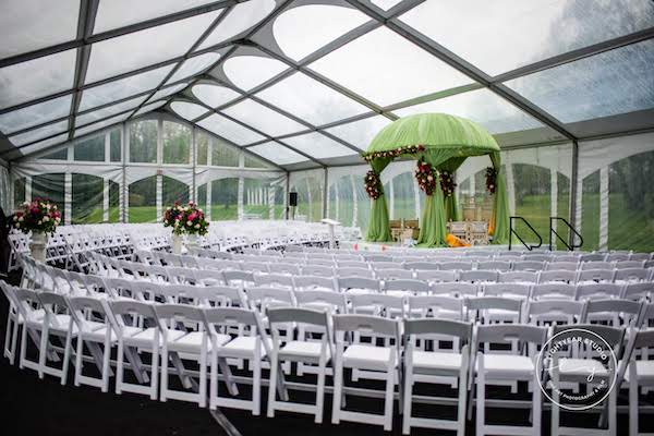 clear tent - wedding ceremony in a clear tent - white garden chairs - Indian wedding ceremony - mandap - green fabric mandap