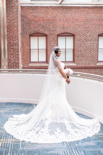 bride in lace wedding gown - bride with long veil - bride on balcony in a lace wedding gown