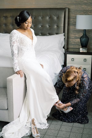 bride's mother helping her get dressed