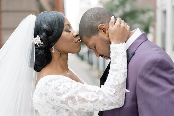 bride kissing groom's forehead on the steps of the Union League of Philadelphia