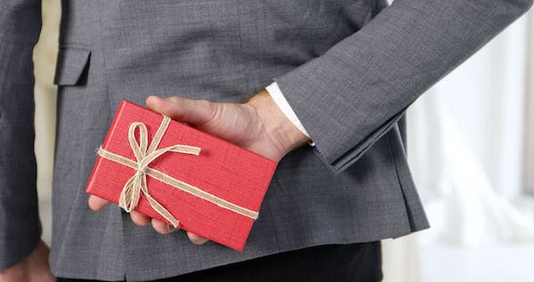 best man bringing groom's gift to the bride