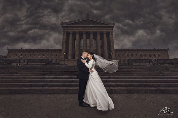 Hispanic bride and groom posing for photos on the step of the Philadelphia Museum of Art