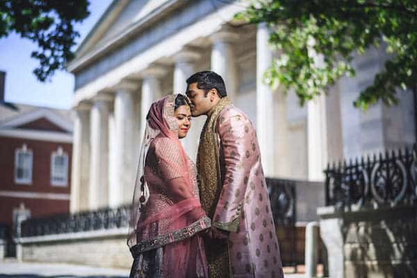 South Asian bride and groom posing for wedding portraits on the steps of the iconic Second Bandk of the United States in Old City Philadelphia