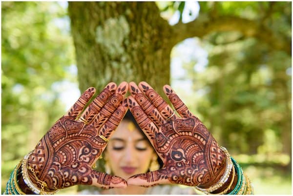 beautiful Indian bride showing henna on the palms of her hands