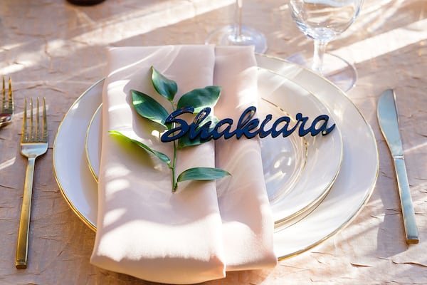 elegant gold layered place setting with custom acrylic name at a micro wedding