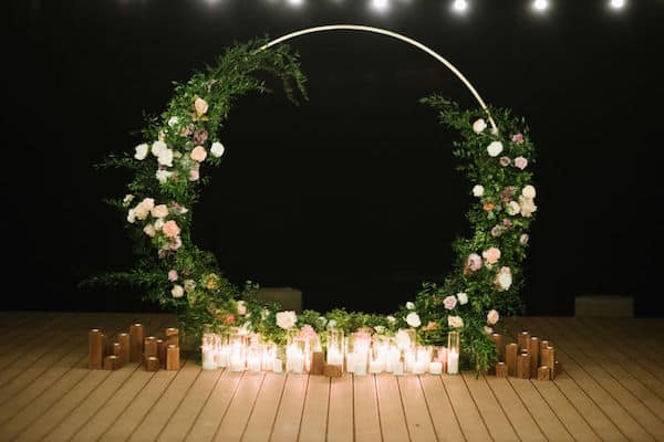 wedding ceremony structure draped in lush greenery that really makes the flowers pop