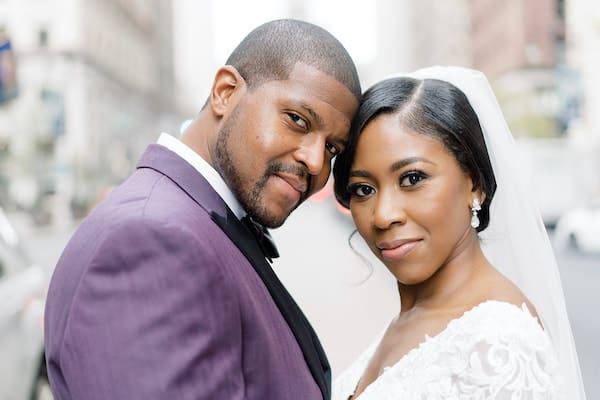 Philadelphia bride and groom posing for wedding photos on South Broad Street near Philadelphia City Hall