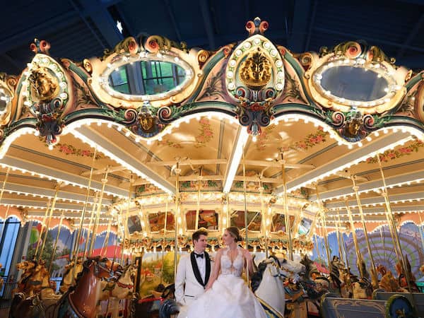 Bride and groom in front of the carousel at the Please Touch Museum