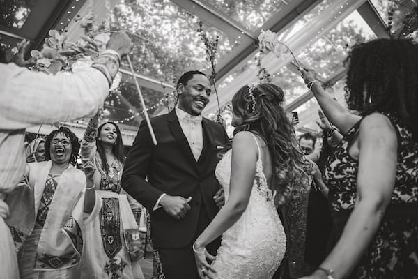 Philadelphia bride and groom entering under an arch of flowers to entered to an Eritrean song, ‘Lega Shibo’ by Hani Mihreteab