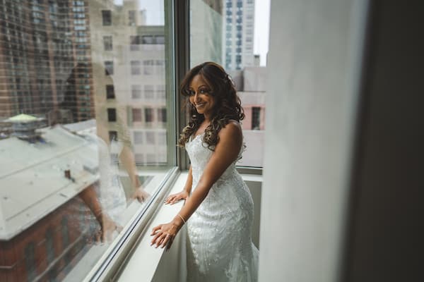 bride in a lace wedding gown looking out the window at traffic on South Broad Street