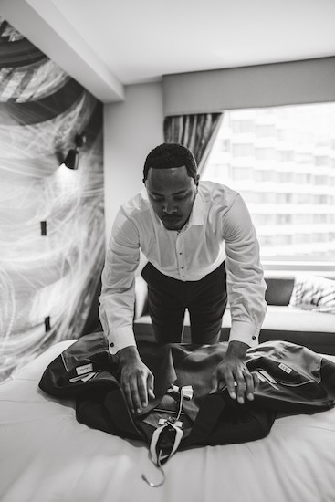 groom fixing his jacket in preparation for his first look with his bride