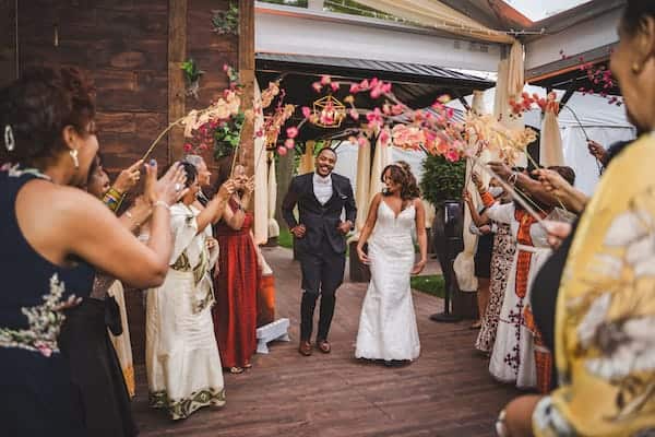 Philadelphia bride and groom entering under an arch of flowers to entered to an Eritrean song, ‘Lega Shibo’ by Hani Mihreteab