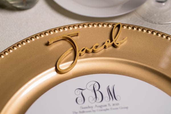 Classic gold charger plate with a custom menu card and gold script name plate