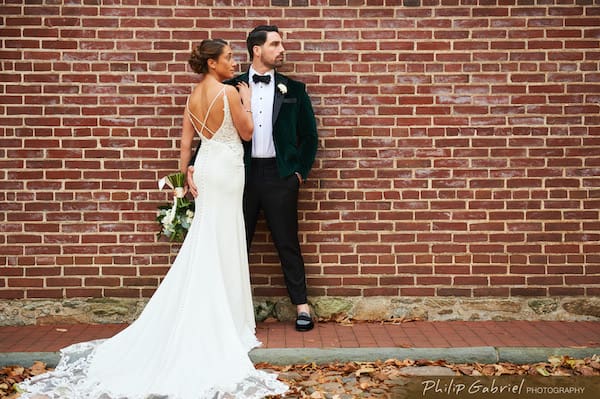 Philadelphia bride and groom posing against a vintage brick wall