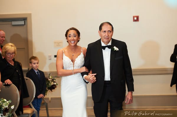 Bride and father walking down the aisle at her Hilton Penn's Landing wedding ceremony