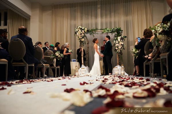 Bride and groom under a birch wood chuppa during thier Philadelphia wedding