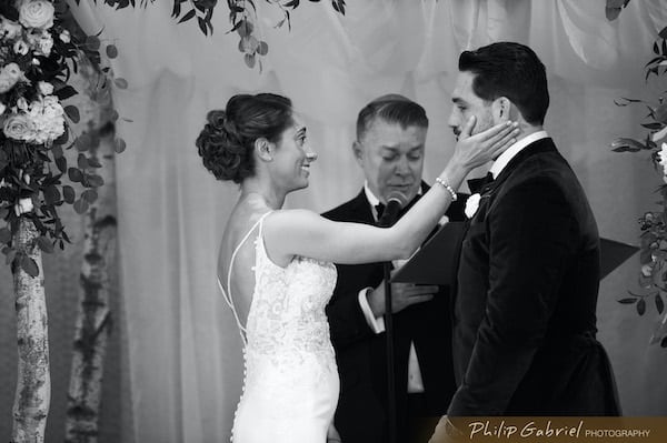 Philadelphia bride touching her grooms face in an emotion moment during their wedding ceremony