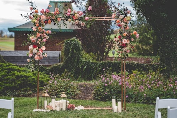 floral covered wedding structure surrounded by lanterns