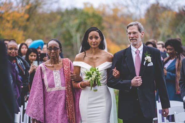 Bride being escorted down the aisle by her parents