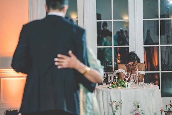 bride sobbing watching her groom dance with his mother