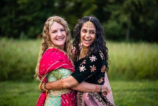 Two brides embracing during thieir south Asian Country chic wedding