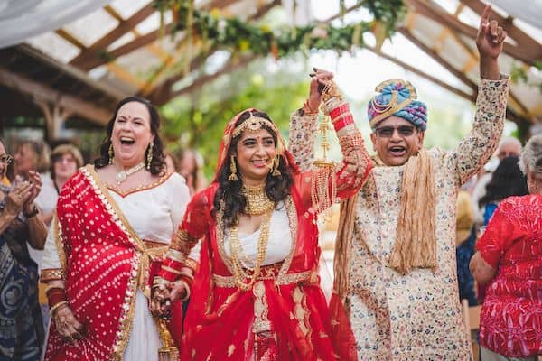 South Asian bride walking down the aisle with her parents