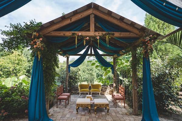 a modern country chic mandap draped in teal fabric