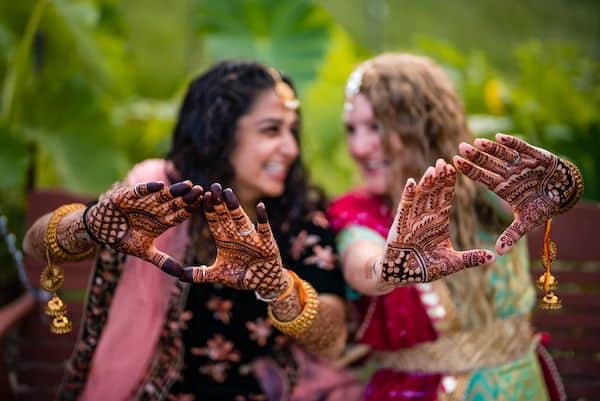 two brides showing off henna at their West Chester wedding rehearsal