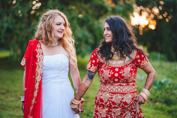 two beautiful bride during thier South Asian County chic multicultural wedding