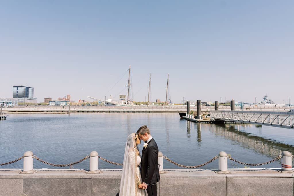 bride and groom in front of harbor