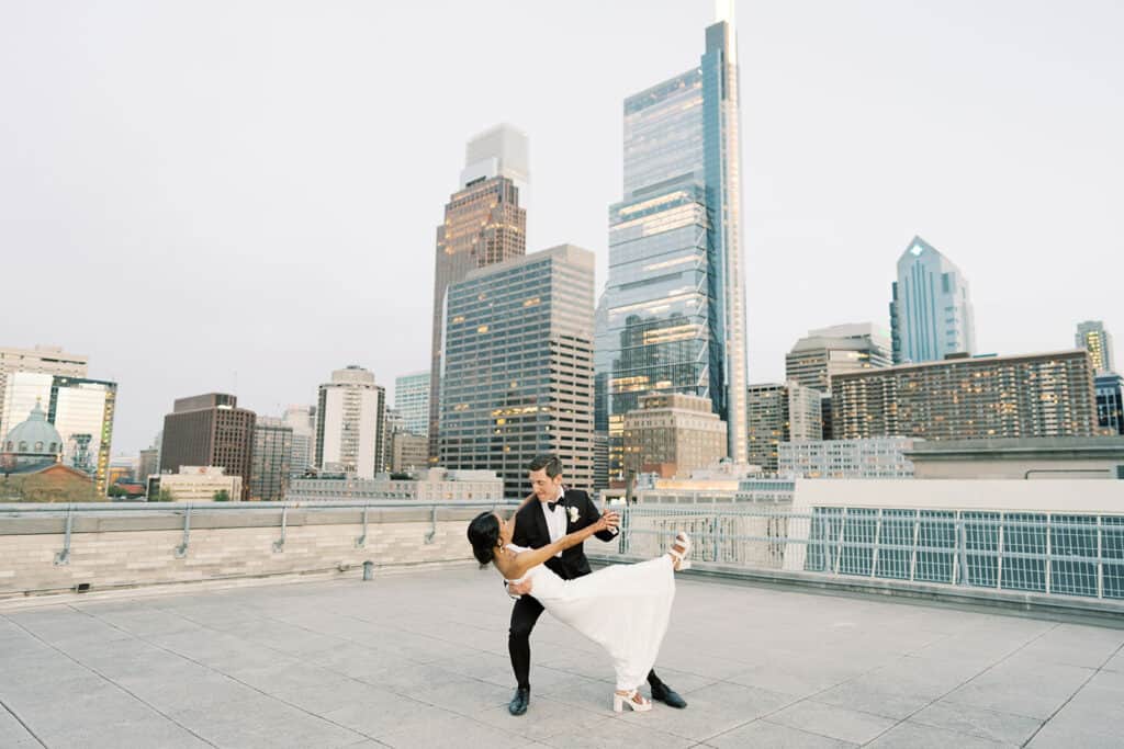 Bride and groom dancing in front of the Philadelphia skyline at The Franklin Institute