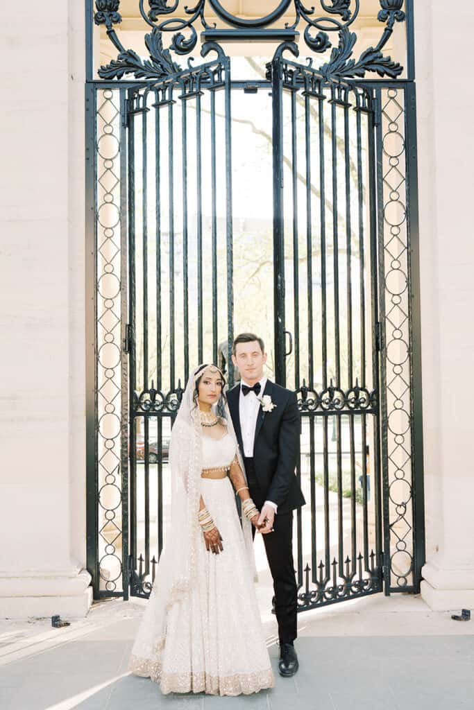 Bride and groom in front of gates at the Rodin Museum wedding venue