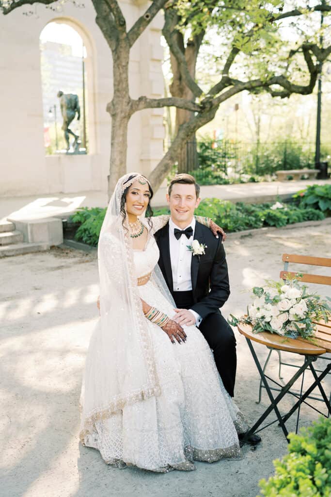 Bride and groom sit outside of the Rodin Museum wedding venue