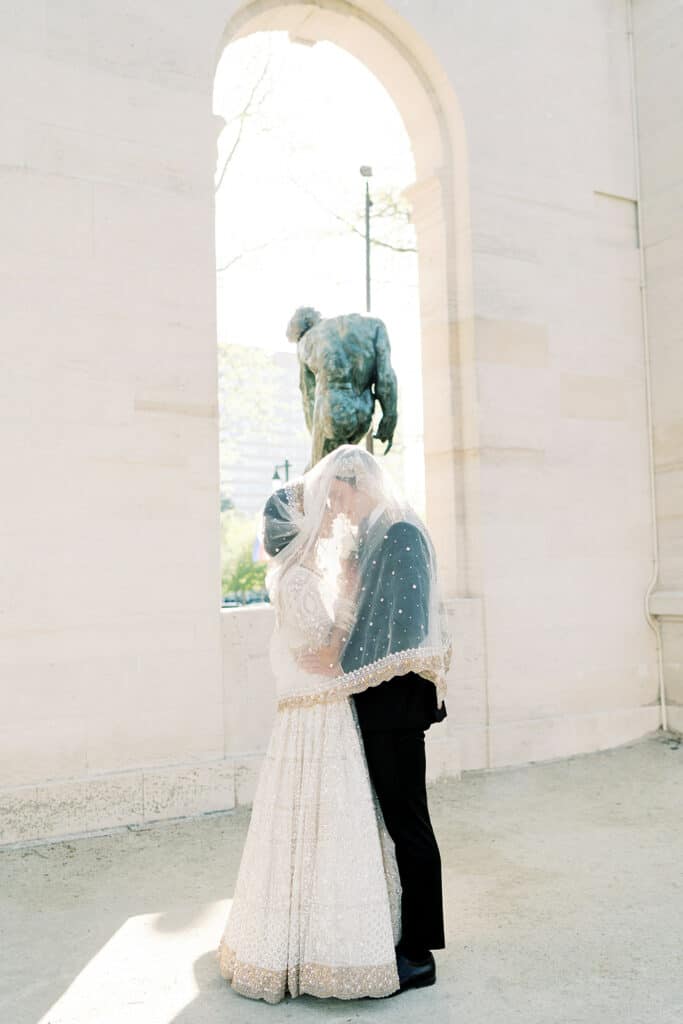 Bride and groom in front of a statue at a Rodin Museum wedding